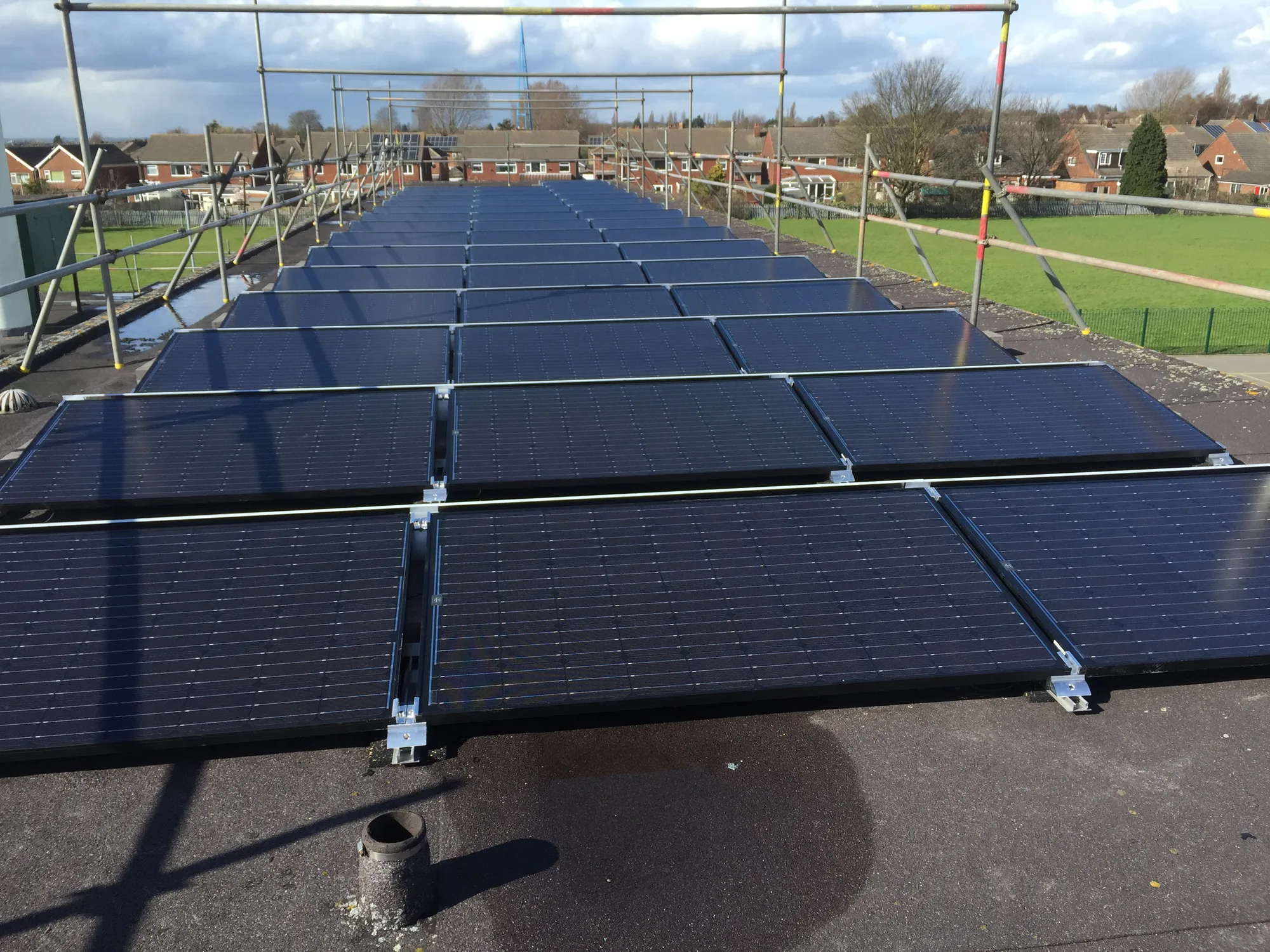 Flat-roof solar installation with safety scaffolding in place
